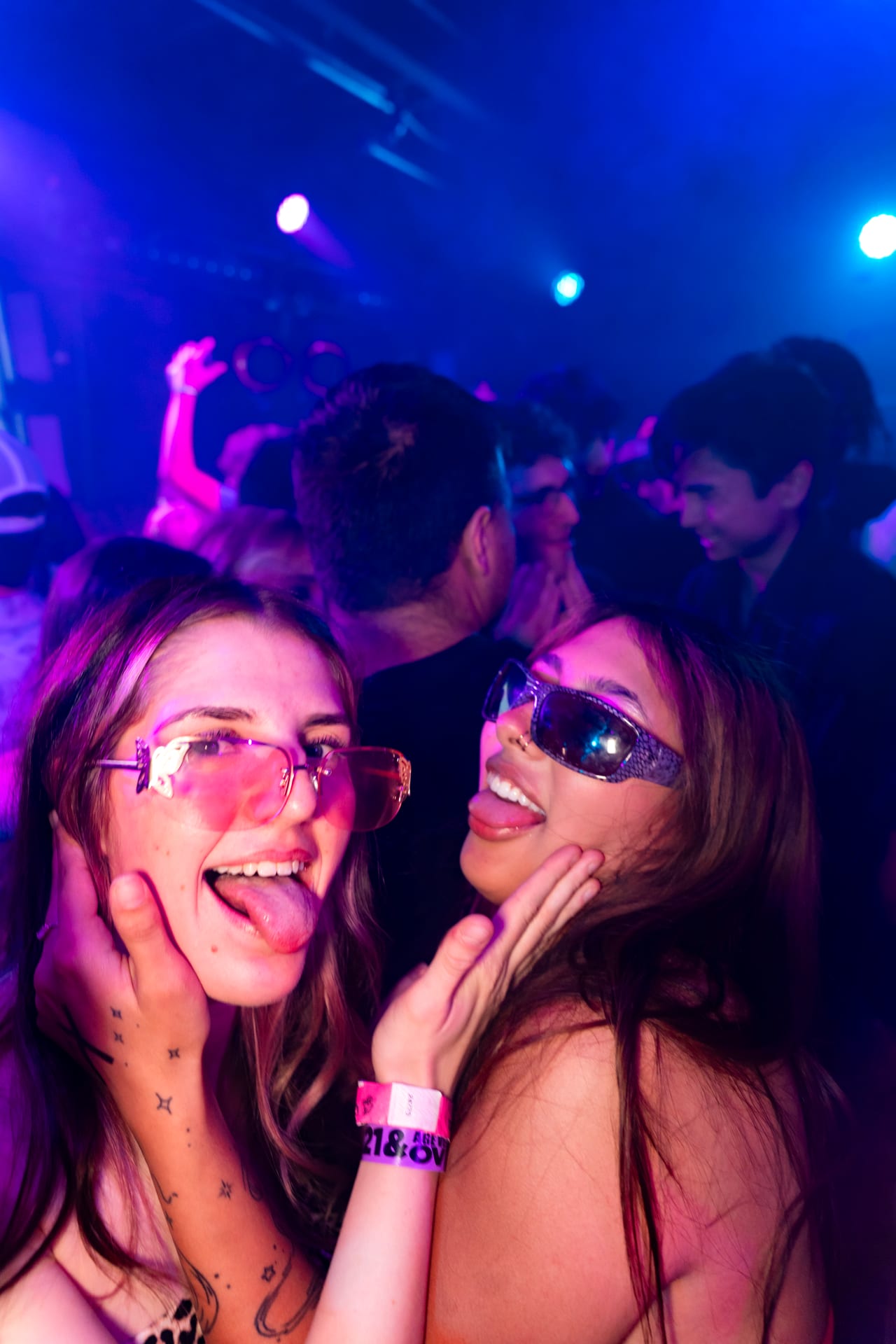 Guests on the floor at CTRL lit by blue and magenta beams from the room's overhead lighting rig.